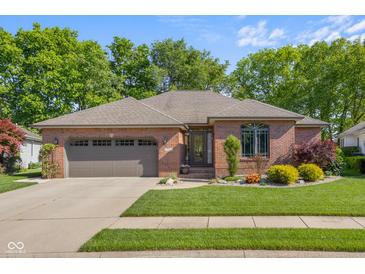 Charming single-story brick home featuring a two-car garage and meticulously landscaped front yard at 3781 S Station Dr, Columbus, IN 47203