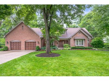 Charming brick home featuring a two-car garage and a lush green lawn at 6575 Robin Hood Dr, Indianapolis, IN 46227