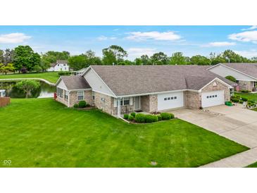 Charming townhome with well-maintained landscaping, attached garage, and lovely pond views at 7937 Bentley Commons Dr, Indianapolis, IN 46259