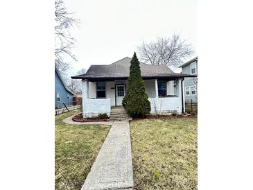 Charming home featuring a stone walkway and an evergreen tree in the front yard at 834 N Temple Ave, Indianapolis, IN 46201
