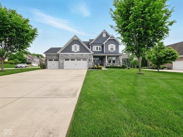 Beautiful two-story home with a three-car garage and meticulously manicured lawn and landscaping at 165 N Bend Dr, Greenwood, IN 46142