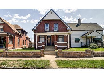 Charming two-story brick home featuring a quaint front porch and well-maintained lawn at 1867 Barth Ave, Indianapolis, IN 46203