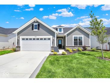 Charming home with a two-car garage, gray siding, stone accents, and a well-manicured lawn on a beautiful day at 19725 Highclere Lane, Sheridan, IN 46069