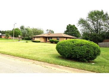 Charming brick ranch home featuring a lush lawn and mature landscaping at 2315 Redfern Dr, Indianapolis, IN 46227
