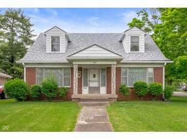 Charming brick home with dormer windows, well-kept lawn, and decorative front porch columns at 301 N Kitley Ave, Indianapolis, IN 46219