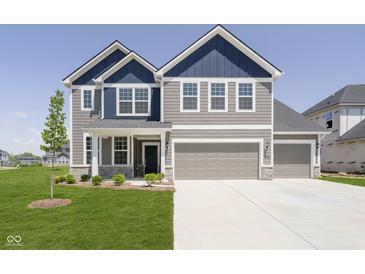 Beautiful two-story home with a three car garage, blue accents and well manicured lawn at 3226 Promenade Way, Brownsburg, IN 46112