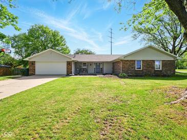 Charming single-story brick home with an attached garage and a well-manicured front lawn at 5200 N Leslie Dr, Muncie, IN 47304