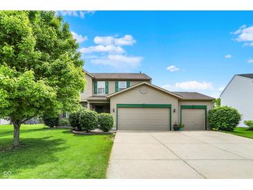Charming two-story home with a three-car garage, well-manicured lawn, and mature tree at 5523 Gainesway Dr, Greenwood, IN 46142