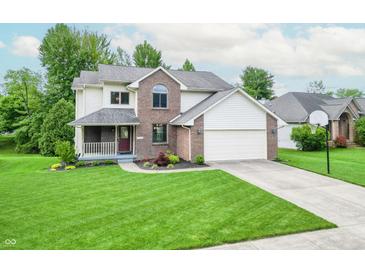 Charming two-story home with brick and vinyl siding, a manicured lawn, and an attached two-car garage at 6039 Chinkapin Dr, Columbus, IN 47201