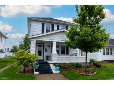 Charming two-story home with a covered front porch and beautifully landscaped yard at 1207 Chestnut St, Columbus, IN 47201