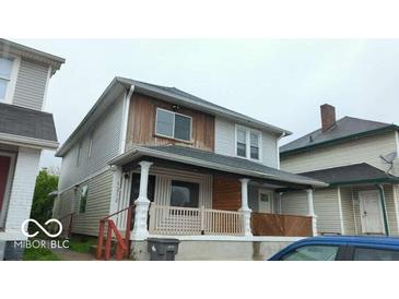 Two-story home featuring a covered front porch, two windows, and a wooden facade at 1212 S Senate Ave, Indianapolis, IN 46225