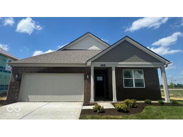 Charming single-story brick home featuring a two-car garage and neatly landscaped front yard at 1266 Foxtail Ln, Greenwood, IN 46143