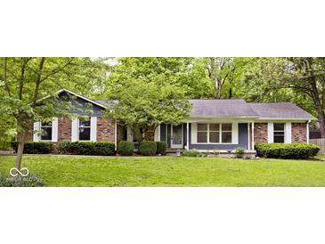 Charming single-story home with brick accents, large windows, and a well-manicured lawn with mature trees at 19446 Ethan Allen Ln, Westfield, IN 46074
