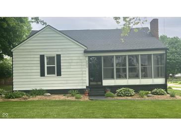 Charming home featuring a lovely screened-in porch, manicured lawn, and appealing front yard landscaping at 3324 S Walnut St, Muncie, IN 47302