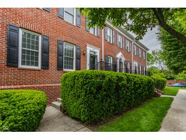Brick townhouse with black shutters, manicured bushes and a sidewalk in front of the homes at 4332 Heyward Pl, Indianapolis, IN 46250