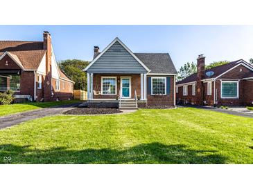 Charming brick home with a cozy front porch and a well-manicured lawn at 5428 E 10Th St, Indianapolis, IN 46219