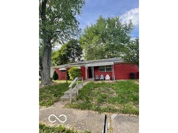 Cozy single-story red home featuring a covered porch and a classic design at 5802 Bertha St, Indianapolis, IN 46241