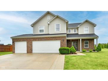 Charming two-story home featuring a two-car garage, brick and siding exterior, and a well-manicured lawn at 7604 Cloudy Ct, Camby, IN 46113