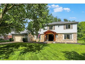 Two-story home with stone facade, attached garage, mature trees, and manicured lawn at 781 Dayton Dr, Carmel, IN 46033