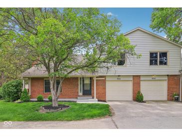 Charming home featuring a well-manicured lawn and attached two-car garage at 9054 Cinnebar Dr, Indianapolis, IN 46268