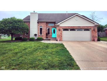 Charming brick home with a well-manicured lawn and inviting turquoise front door at 1026 Summer Way Dr, Shelbyville, IN 46176