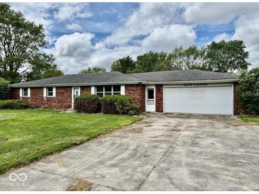 Charming brick ranch-style home featuring an attached garage, mature trees, and an expansive front yard at 1103 Canal St, Anderson, IN 46012