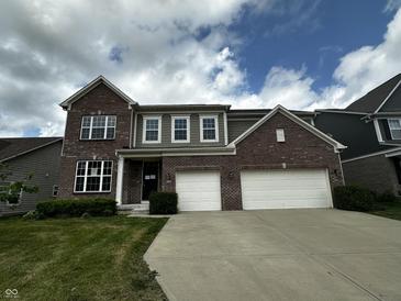 Attractive two-story brick home with a well-manicured lawn and a two car garage at 14462 Brook Meadow Dr, McCordsville, IN 46055