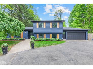 Eye-catching exterior of a blue house with charming wooden shutters and well-manicured landscaping at 1829 Kessler Blvd W Dr, Indianapolis, IN 46228