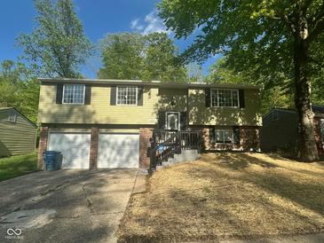 Charming two-story home features a welcoming front porch, an attached three-car garage and manicured front yard at 3541 Alpine Pl, Indianapolis, IN 46226