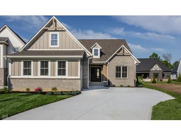 Charming home with a brick and siding exterior, complemented by a well-manicured lawn and a concrete driveway at 4190 Hartswick Ct, Zionsville, IN 46077