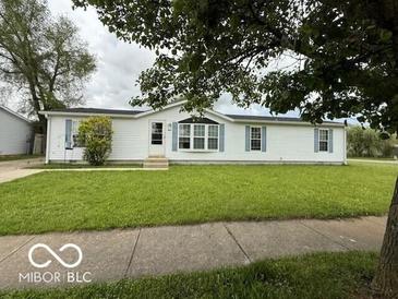 Charming single-story home with white siding, blue shutters, and manicured front lawn at 4617 Autumn Ridge Dr, Columbus, IN 47203