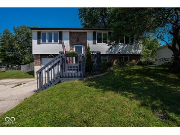Charming split-level home featuring a brick facade, siding, and well-maintained lawn at 5522 Closser Ct, Indianapolis, IN 46221
