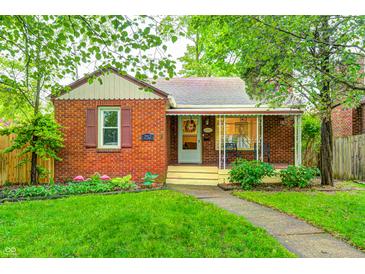 Charming brick home with a manicured front lawn, mature trees, and a cozy front porch at 752 N Leland Ave, Indianapolis, IN 46219