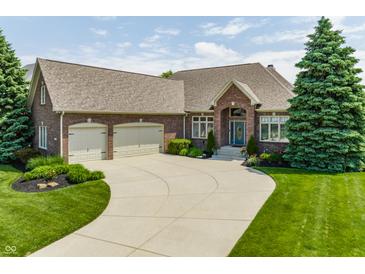 Charming brick home with a well-manicured lawn, mature trees, and an attached two-car garage at 10784 Giselle Way, Fishers, IN 46040