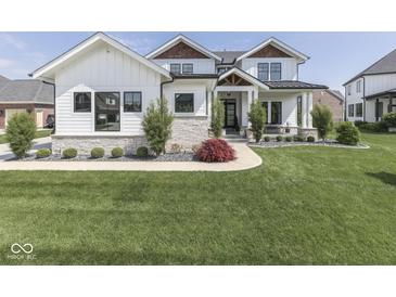 Charming two-story home boasting a manicured lawn, stone accents, and tasteful landscaping elements at 14464 Gainesway Cir, Fishers, IN 46040