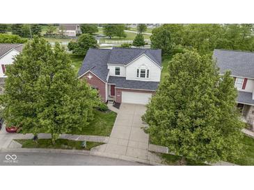 Charming two-story home featuring brick accents and a well-manicured lawn surrounded by mature trees at 14542 Baldwin Ln, Carmel, IN 46032