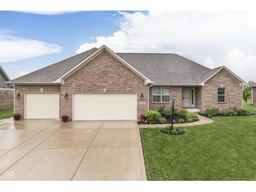 Charming brick home with a well-manicured lawn, a two-car garage and a welcoming entrance at 1751 S Centennial Ave, New Palestine, IN 46163