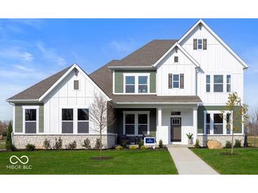 Charming two-story home with a mix of white and green siding, complemented by a well-manicured lawn and stone accents at 19848 Chatsworth Blvd, Westfield, IN 46074