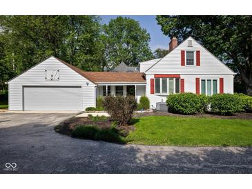 Charming home featuring a well-maintained lawn, red shuttered windows, and attached two car garage at 2929 E 62Nd St, Indianapolis, IN 46220