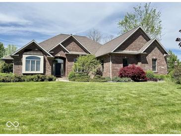 Charming brick home with well-manicured lawn and mature landscaping offers great curb appeal at 5200 W Shoreline Ter, Muncie, IN 47304