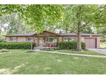 Charming brick ranch home featuring a well-manicured lawn and inviting curb appeal with a covered front entry at 5427 Heights Ave, Indianapolis, IN 46237