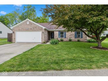 Charming brick home featuring a well-manicured lawn, mature trees, and an attached two-car garage at 560 Old Farm Rd, Danville, IN 46122