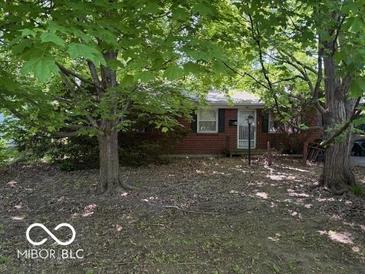 Cozy brick home with mature trees and a well-maintained front yard at 7141 E 48Th St, Indianapolis, IN 46226