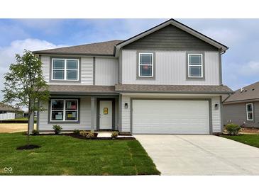 Charming two-story home with a well-manicured lawn, two-car garage, and light gray siding at 1204 Mcbride St, Greenfield, IN 46140