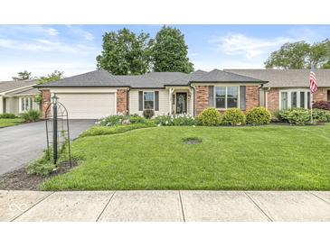 Charming ranch-style home with a well-manicured lawn and inviting curb appeal in a peaceful neighborhood at 12388 Camberley Ln, Carmel, IN 46033
