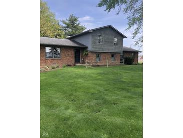 Charming two-story home with a brick facade and a spacious front yard, complemented by a rustic wooden fence at 21749 Oak Ridge Rd, Sheridan, IN 46069