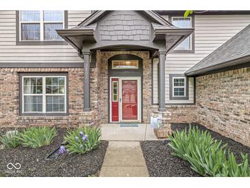 Charming front entrance with a red door, brick facade, and well-maintained landscaping creating curb appeal at 2802 Singletree Dr, Indianapolis, IN 46234