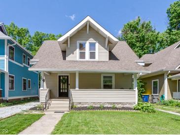 Charming craftsman home featuring a welcoming front porch and a well-manicured lawn at 344 N Whittier Pl, Indianapolis, IN 46219