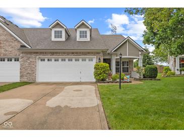 Charming brick home featuring a two-car garage, well-manicured lawn, and inviting curb appeal at 4907 Franklin Villas Pl, Indianapolis, IN 46237