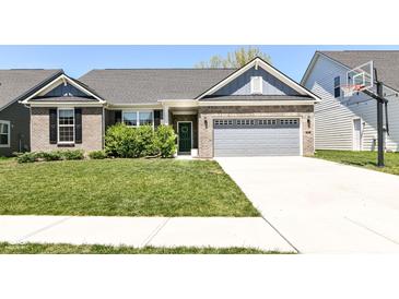Charming brick home featuring a two-car garage, well-manicured lawn, and inviting curb appeal at 6832 Oakcrest Dr, McCordsville, IN 46055